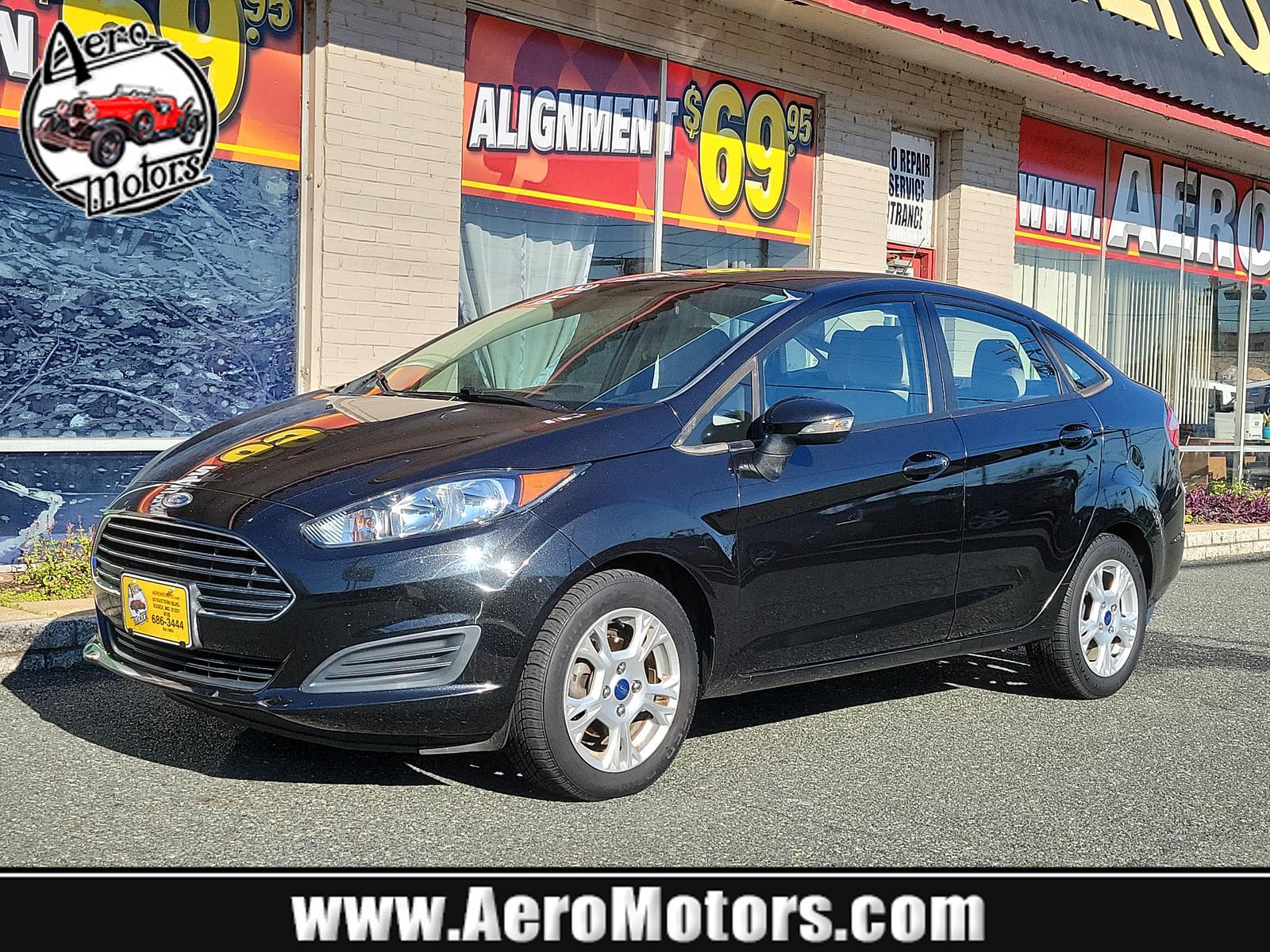 2014 Tuxedo Black Metallic /Medium Light Stone Ford Fiesta SE (3FADP4BJ1EM) with an ENGINE: 1.6L TI-VCT I-4 engine, located at 50 Eastern Blvd., Essex, MD, 21221, (410) 686-3444, 39.304367, -76.484947 - Look at this 2014 Ford Fiesta SE Sedan shown in Tuxedo Black. This subcompact is powered by a 1.6 Liter Ti-VCT 4 Cylinder that offers 120hp while paired to a 6 Speed Automatic transmission to give you with plenty of zip. This Front Wheel Drive sedan offers you nearly 39mpg on the highway. You will l - Photo #0