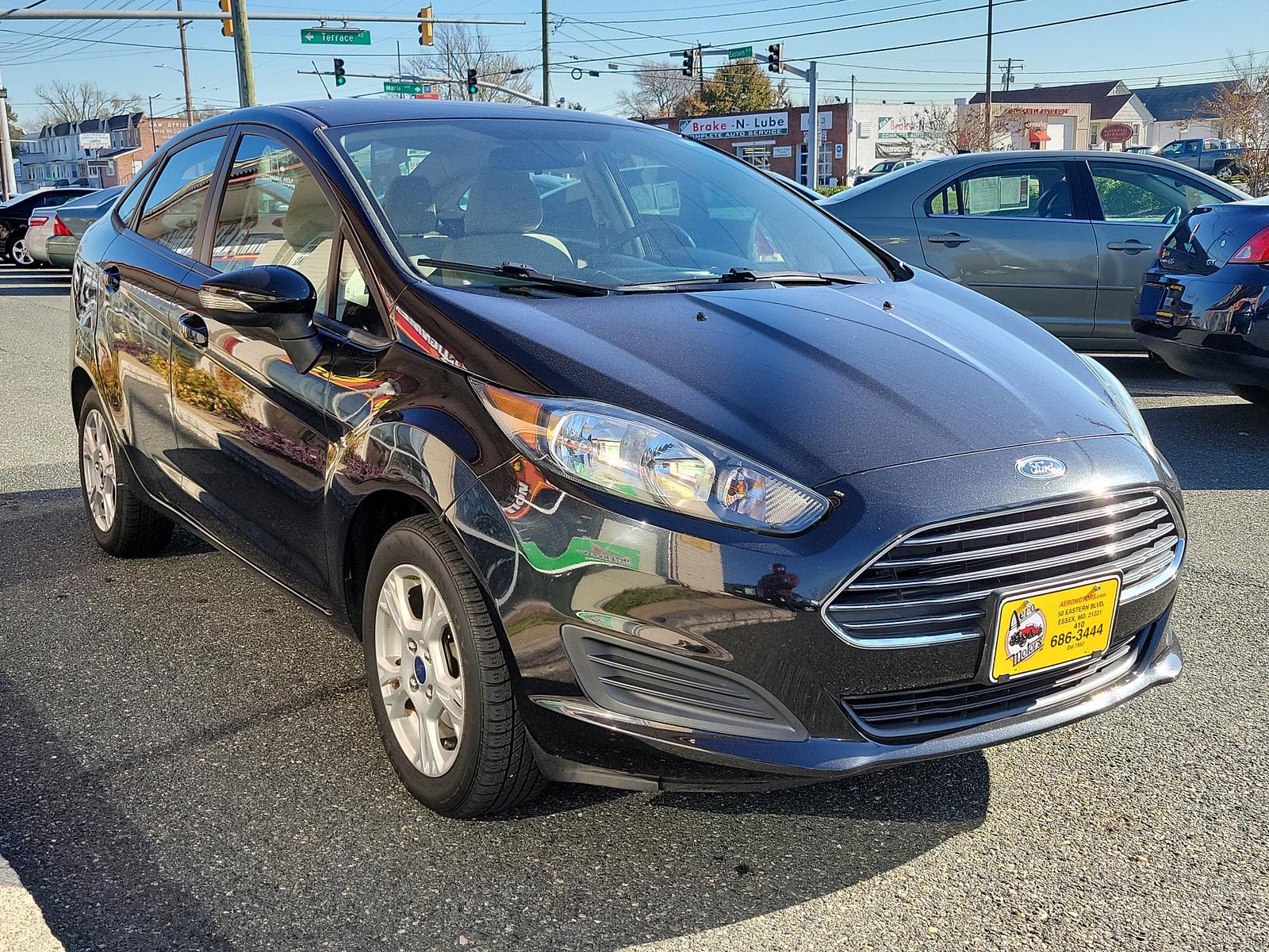 2014 Tuxedo Black Metallic /Medium Light Stone Ford Fiesta SE (3FADP4BJ1EM) with an ENGINE: 1.6L TI-VCT I-4 engine, located at 50 Eastern Blvd., Essex, MD, 21221, (410) 686-3444, 39.304367, -76.484947 - Look at this 2014 Ford Fiesta SE Sedan shown in Tuxedo Black. This subcompact is powered by a 1.6 Liter Ti-VCT 4 Cylinder that offers 120hp while paired to a 6 Speed Automatic transmission to give you with plenty of zip. This Front Wheel Drive sedan offers you nearly 39mpg on the highway. You will l - Photo #2