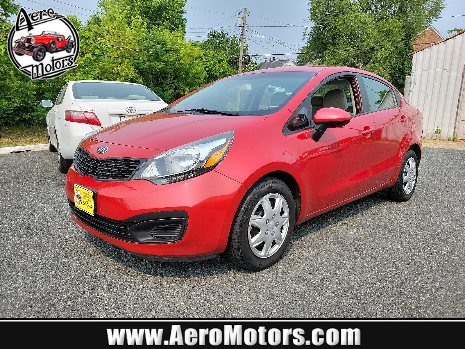 2013 Signal Red - BEG /Beige - DCM Kia Rio LX (KNADM4A32D6) with an 1.6L DOHC GDI dual CVVT 16-valve I4 engine -inc: variable intake system (VIS), aluminum block and head, full-size engine cover engine, located at 50 Eastern Blvd., Essex, MD, 21221, (410) 686-3444, 39.304367, -76.484947 - <p>You've found our sporty and ultra-efficient 2013 Kia Rio LX Sedan shown in Signal Red. Powered by a 1.6 Liter 4 Cylinder that delivers 138hp paired to the smooth-shifting 6 Speed Automatic transmission gives excellent passing power. You can achieve nearly 40mpg on the road with Front Wheel Drive. - Photo #0